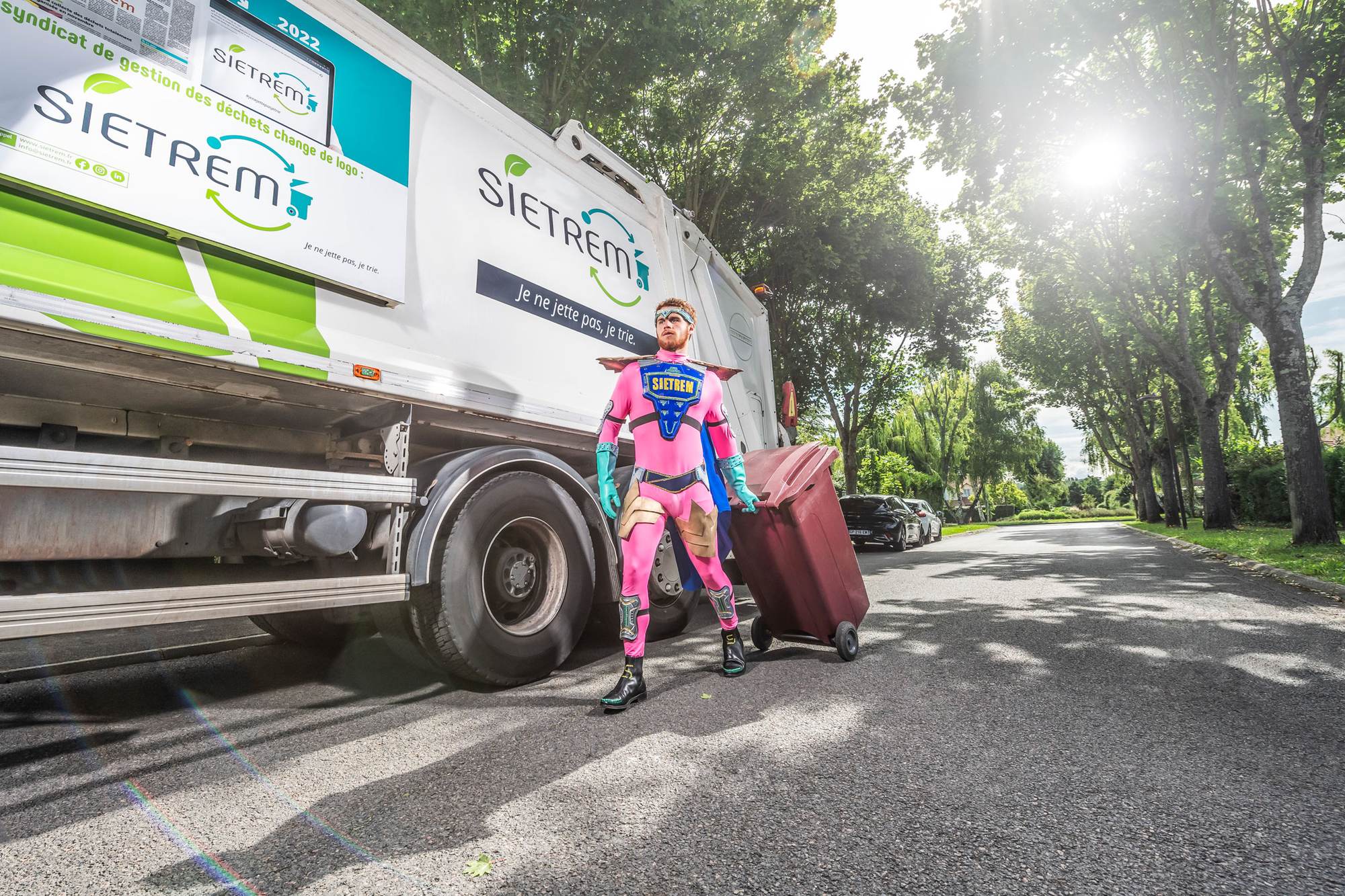 Super-héros SIETREM aux côtés d'un camion de collecte aux couleurs du syndicat.